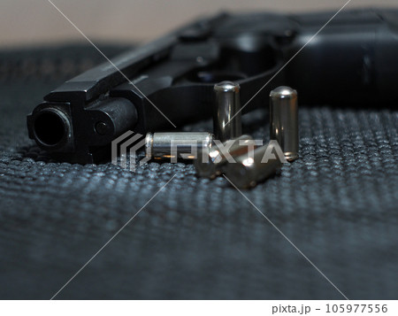 Close-up of a pistol with ammunition. Close-up of a pistol with ammunition. 105977556