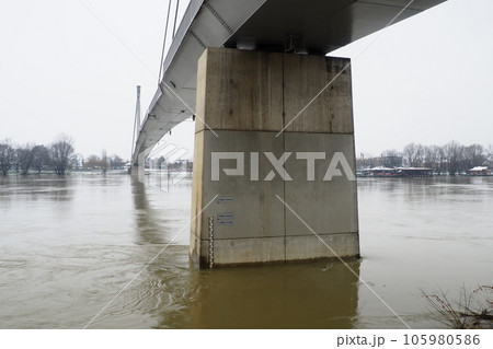 Sremska Mitrovica, Serbia, 01.27.2023 Bridge over the river Sava. Flooding after heavy rains and melting snow. A swift flow of muddy water. Hydrological scale for measuring the level of water Sremska Mitrovica, Serbia, 01.27.2023 Bridge over the river Sava. Flooding after heavy rains and melting snow. A swift flow of muddy water. Hydrological scale for measuring the level of water 105980586