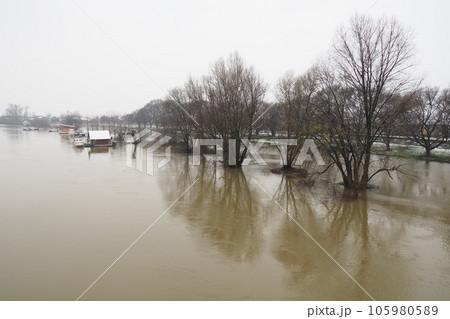 Macvanska Mitrovica, Serbia, 01.27.2023 The bridge over the Sava River. Flooding after heavy rains and snowmelt. A swift flow of muddy water. Trees, boats and piers in the water. Machva in winter Macvanska Mitrovica, Serbia, 01.27.2023 The bridge over the Sava River. Flooding after heavy rains and snowmelt. A swift flow of muddy water. Trees, boats and piers in the water. Machva in winter 105980589