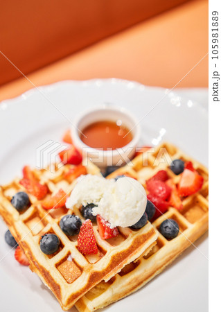 Classic Viennese waffles with ice cream, berries and Maple syrup. Breakfast in cafe. Table in the restaurant. 105981889