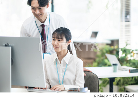 部下に画面を見ながら説明するビジネスマン 部下に画面を見ながら説明するビジネスマン 105982214