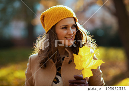 happy trendy woman in beige coat and orange hat happy trendy woman in beige coat and orange hat 105982558