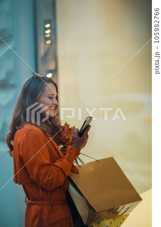 smiling trendy woman in brown trench coat smiling trendy woman in brown trench coat 105982766