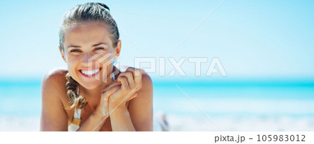 smiling young woman laying on beach smiling young woman laying on beach 105983012