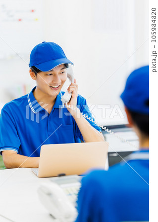 オフィスでデスクワークを行う作業服を着たドライバー オフィスでデスクワークを行う作業服を着たドライバー 105984820