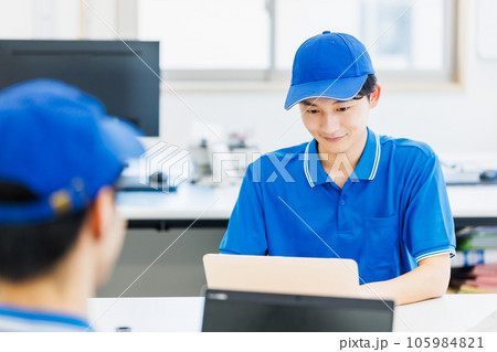 オフィスでデスクワークを行う作業服を着たドライバー オフィスでデスクワークを行う作業服を着たドライバー 105984821