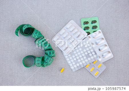 Slimming pills and measuring tape. Diet. 105987574
