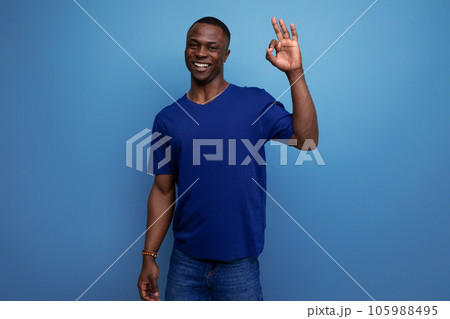 attractive 25s african guy in casual blue t-shirt showing finger ok attractive 25s african guy in casual blue t-shirt showing finger ok 105988495