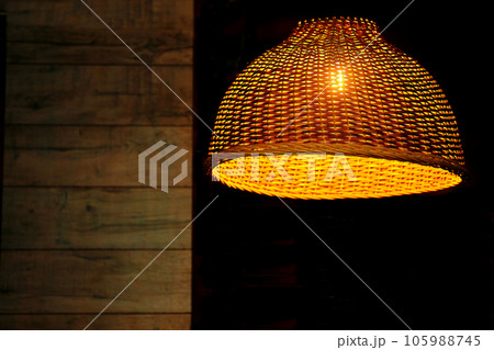Glowing electric lamp in a wicker lampshade at dusk.Place for text 105988745