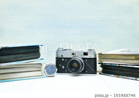 Old vintage film photo camera with photo album and watch isolated on pale pink 105988746