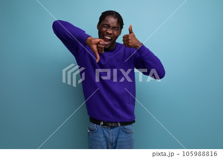 portrait of a doubtful dark-skinned european young adult in a blue hoodie and jeans isolated on a 105988816