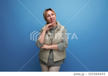 well-groomed blond youthful woman in spring clothes isolated on blue background well-groomed blond youthful woman in spring clothes isolated on blue background 105988845
