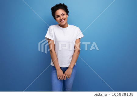 portrait of authentic beautiful young brunette hispanic woman in white t-shirt on background with 105989139