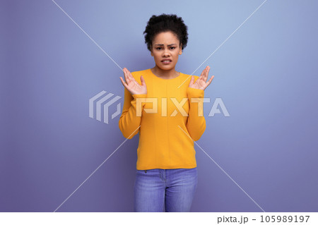 confused young latin woman with afro hair on studio background 105989197