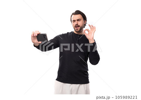 portrait of a well-built European young macho man with black hair and a beard in a black jacket 105989221
