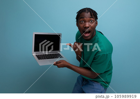 charismatic consultant demonstrates laptop screen on studio background with mockup and copy space 105989919