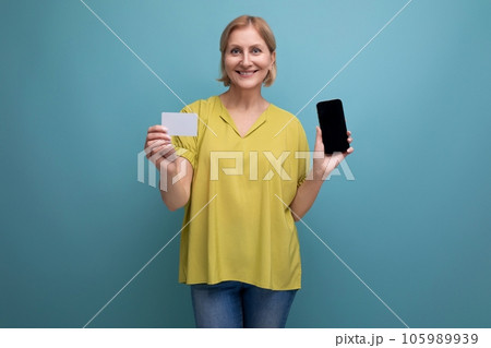 smiling blonde 50s woman holding plastic card to pay for purchases mockup smiling blonde 50s woman holding plastic card to pay for purchases mockup 105989939