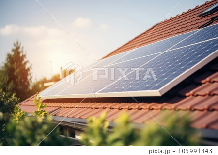 Close up of a new building with solar panels on the roof. Sustainable and clean energy at home. 105991843