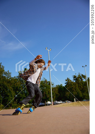 Active teen rollerblading on street having training class 105992206