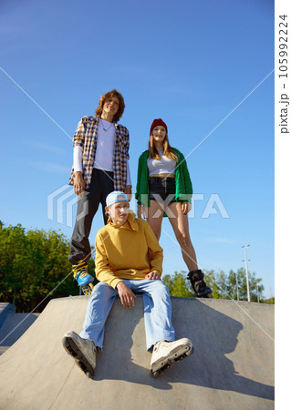 Group of professional teenager skaters sitting on ramp Group of professional teenager skaters sitting on ramp 105992224
