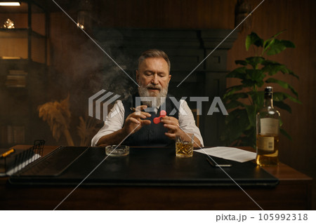 Old-fashioned elegant senior businessman playing spinner toy 105992318
