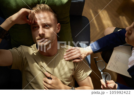 Tired pensive military man feeling worry and despair overhead view 105992422