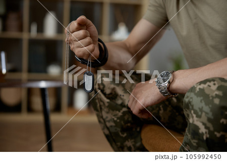 Closeup military person holding fighter dog tag badge in hand Closeup military person holding fighter dog tag badge in hand 105992450