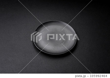 Empty black plate over dark stone background with copy space 105992464