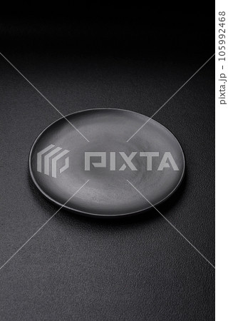 Empty black plate over dark stone background with copy space 105992468