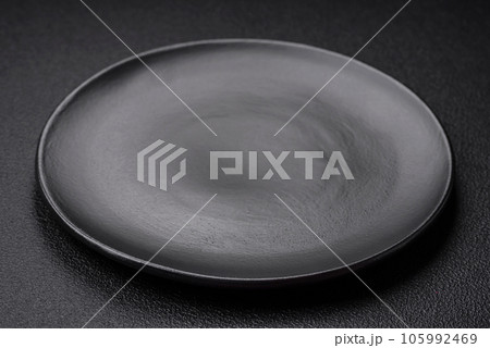 Empty black plate over dark stone background with copy space 105992469