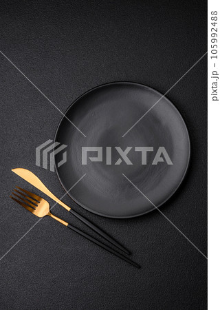 Empty black plate over dark stone background with copy space Empty black plate over dark stone background with copy space 105992488