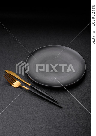 Empty black plate over dark stone background with copy space 105992489