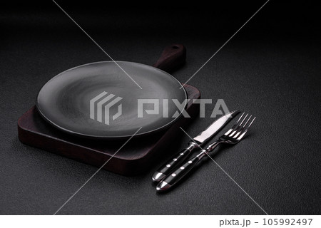 Empty black plate over dark stone background with copy space Empty black plate over dark stone background with copy space 105992497