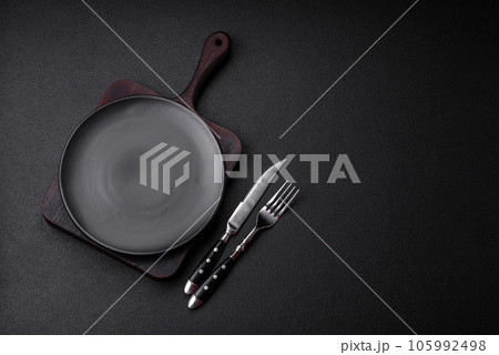 Empty black plate over dark stone background with copy space 105992498