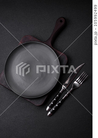 Empty black plate over dark stone background with copy space 105992499