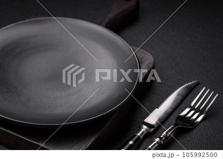 Empty black plate over dark stone background with copy space 105992500