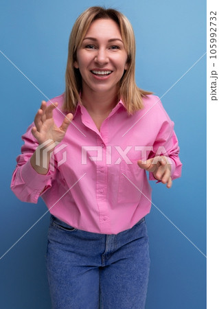 young pretty blond european office worker woman with flowing hair in a pink blouse smiles sweetly 105992732