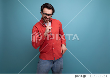 confident stylish 35 year old brunette millennial man with gorgeous hair in a red shirt on a studio confident stylish 35 year old brunette millennial man with gorgeous hair in a red shirt on a studio 105992964
