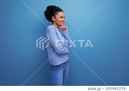 charming 20s brunette woman with afro curls in stylish casual clothes isolated with studio 105993258