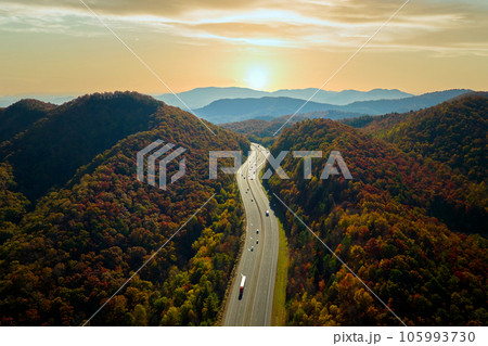 View from above of I-40 freeway route in North Carolina leading to Asheville thru Appalachian mountains with yellow fall woods and fast moving trucks and cars. Interstate transportation concept View from above of I-40 freeway route in North Carolina leading to Asheville thru Appalachian mountains with yellow fall woods and fast moving trucks and cars. Interstate transportation concept 105993730
