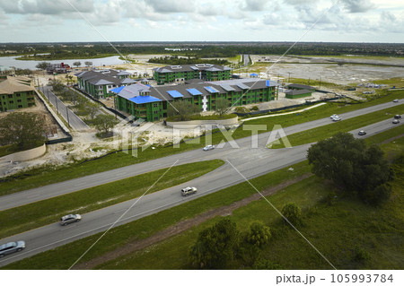 Top view of apartment buildings under construction in developing suburban area near transport infrastructure. Development of residential housing in american suburbs. Real estate market in the USA 105993784