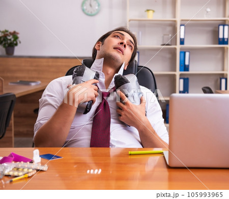 Young drug addicted male employee working in the office 105993965