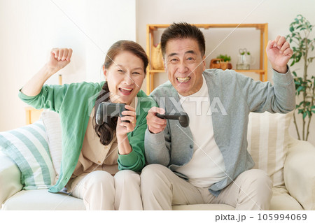 リビングでテレビゲームを楽しむシニア夫婦 リビングでテレビゲームを楽しむシニア夫婦 105994069