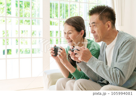 リビングでテレビゲームを楽しむシニア夫婦 105994081