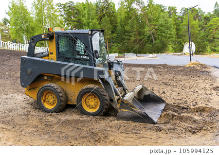 A loader with a bucket clears the site for construction 105994125