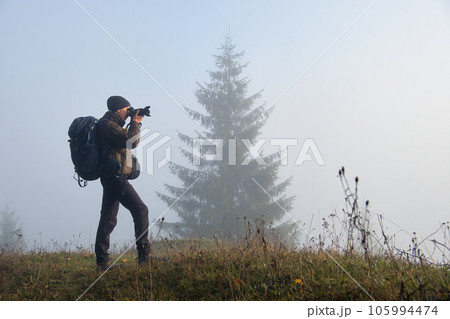 Photographer hiker taking picture of nature with digital camera 105994474