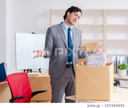 Young man employee with boxes in the office 105994691
