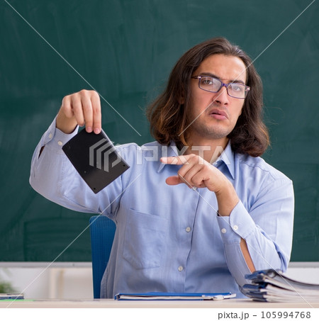 Young male teacher in front of green board Young male teacher in front of green board 105994768