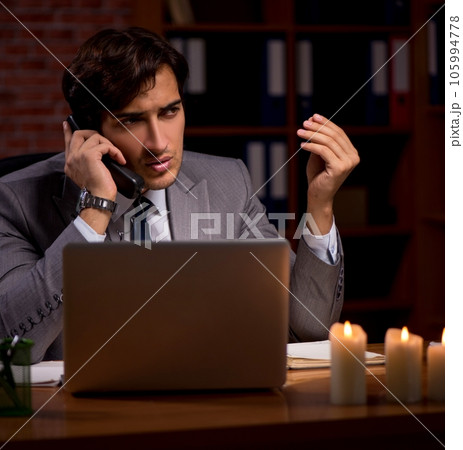 Businessman working late in office with candle light 105994778