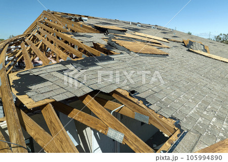 Natural disaster and its consequences. Hurricane Ian destroyed house roof in Florida residential area 105994890